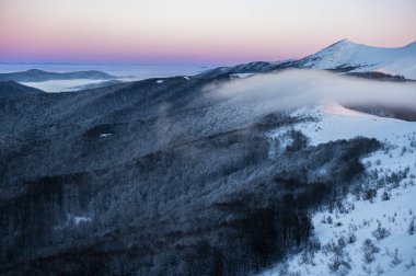 Güzel kış dağ manzarası. Polonya 'nın Bieszczady Ulusal Parkı' ndaki Smerek Dağı 'ndan görülen kasvetli gün batımı.