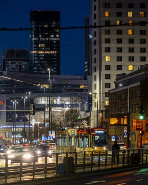 Varşova, Polonya - 26 Aralık 2023: Şehir ışıklarıyla çevrili Tytusa Chalubinski caddesinde bir tramvay. Varşova şehir merkezinin gece manzarası.