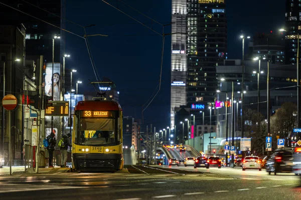 Varşova, Polonya - 26 Aralık 2023: Şehir ışıklarıyla çevrili Tytusa Chalubinski caddesinde bir tramvay. Varşova şehir merkezinin gece manzarası.