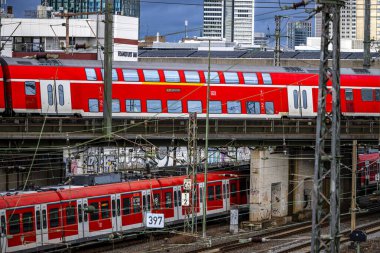 Frankfurt am Main, Germany - December 22, 2024: Trains in a background of railway tracks and the skyline of Frankfurt Financial District clipart