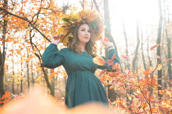 秋天森林里红头发的年轻女子的肖像 一个女孩在一个树叶的花环里 背景是自然界的黑暗树桔树落叶 — 图库照片