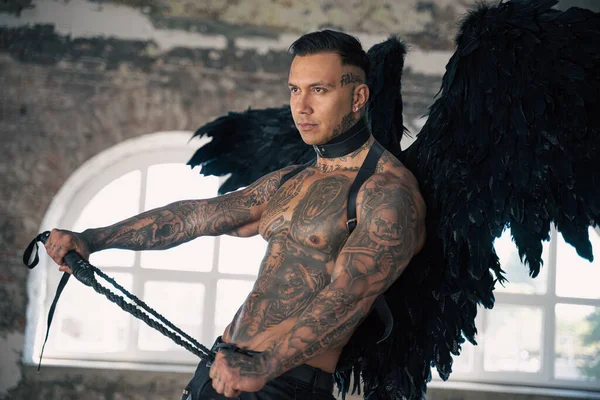man portrait. Close up portrait of handsome male angel. Guy with tattoo. hot man in leather . man with collar and whip. Angle with dark wings