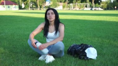 Stadyumdaki sportif kız. Formda bir kadın futbol sahasında dinleniyor. Şekli güzel kız.