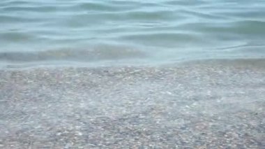 Sahildeki deniz alanı. Sahildeki deniz kumu manzarası. Deniz dalgaları kıyıdaki kayalara çarpıyor ve bir su patlaması yaratıyor.