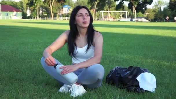 スタジアムの女だ サッカー場でリラックスした女性にフィット 美しい女の子の形 — ストック動画