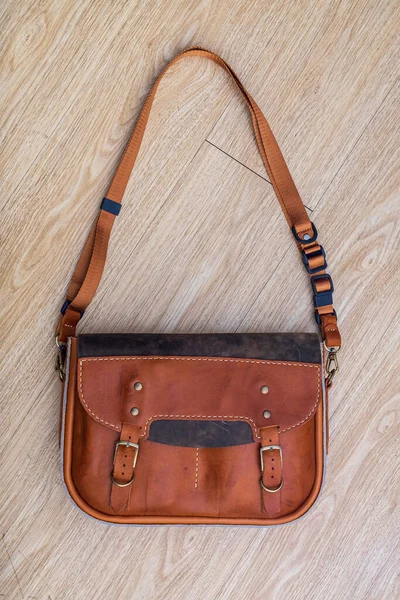 Hand made Genuine Leather Messenger Bag on the floor.