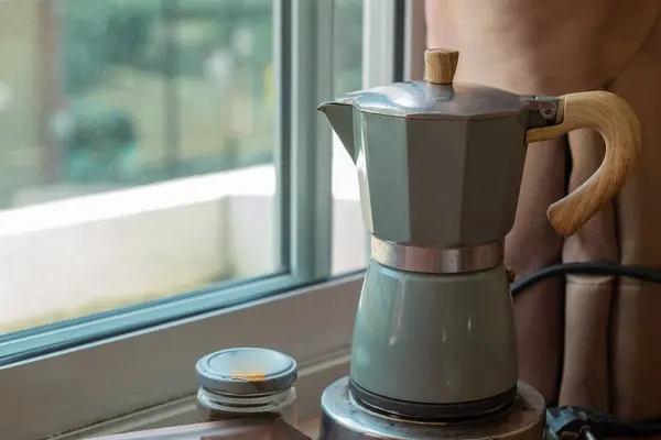 Moka Pot, Coffee pot for brewing coffee on a wooden table. Relax with a cup of coffee in the morning.