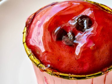 Cömert miktarda çilekli reçelle kaplanmış kapkekler servis edilmeye hazır..