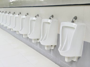 Several urinals in a public restroom that appear clean and well-maintained clipart