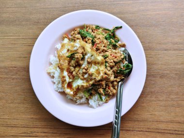 Buharda pişirilmiş yasemin pilavı, kızarmış domuz eti, kutsal fesleğen ve kızarmış yumurta. Lezzetli ve sağlıklı bir yemek..