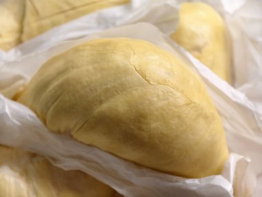 Taze Mon Thong Durian derisinden yakın plan. Kağıt ambalajlı köpük bir kutuya yerleştirilmiş. Kremsi dokusu ve altın sarısı rengi birinci sınıf kalitesini vurguluyor. 