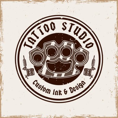Pirinç muştalı ve dövme makineli klasik dövme stüdyosu amblemi. Eski tarz klasik monokrom vektör çizimi, rozetler, tişört izleri ve dövmeyle ilgili tasarımlar için mükemmel.