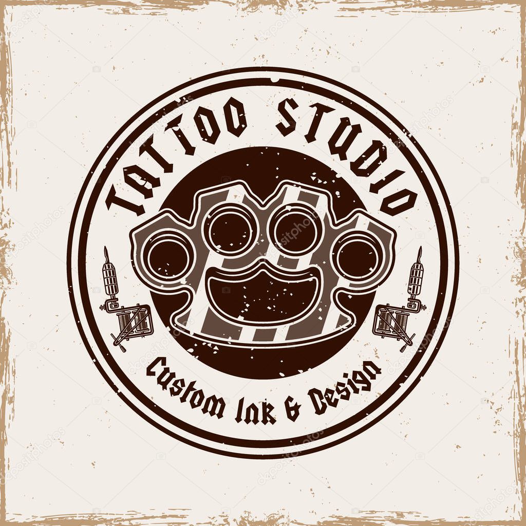 Vintage tattoo studio emblem with brass knuckles and tattoo machines. Classic monochrome vector illustration in retro style, perfect for badges, t-shirt prints and tattoo related designs