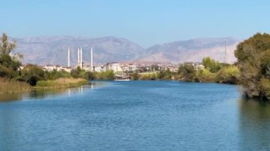 Arka planda Manavgat Nehri 'nde Cami ve Manavgat kentiyle yelken açan tekne, Türkiye