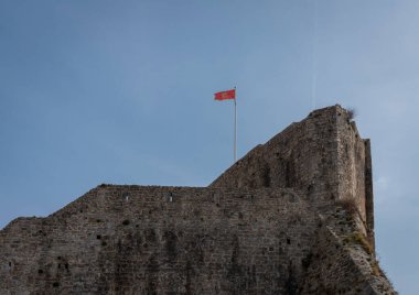 Flag flying from the fortified stone walls of the Old Town of Budva, Montenegro