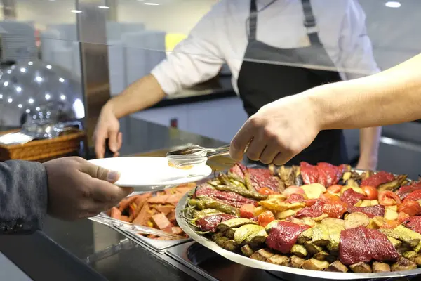 Lokantadaki ana yemeği servis eden şefin yakın çekimi.