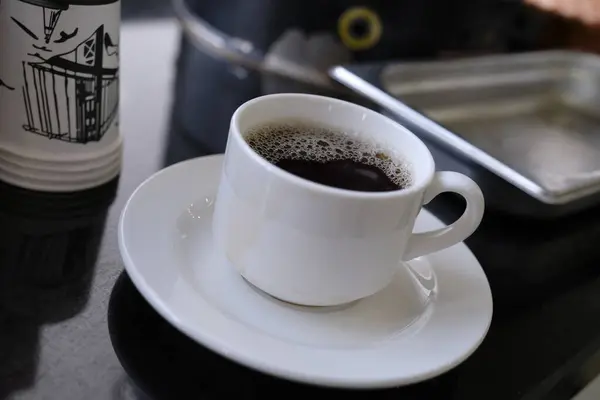 kahve fincanı ve masada kahve çekirdekleri