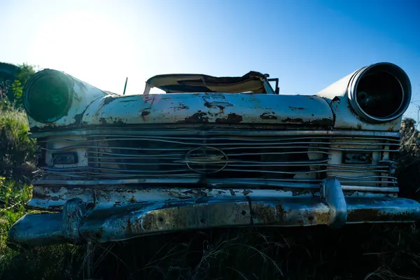 Tarlada terk edilmiş paslı bir araba.