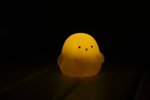 Koyu arkaplanda siyah gözleri olan küçük sarı ve beyaz hayaleti kapat..