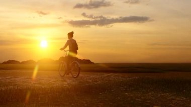 Gün batımında bisikletle dolaşan genç bir kız.