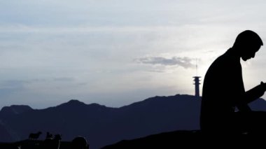 Yüksek bir dağ bölgesindeki cep telefonundan aramaya çalışıyorum.