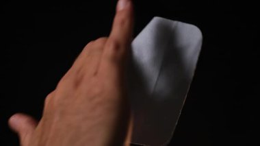 Silahı temizleyen bir elin yakın çekimi, siyah bir arkaplanda izole edilmiş..