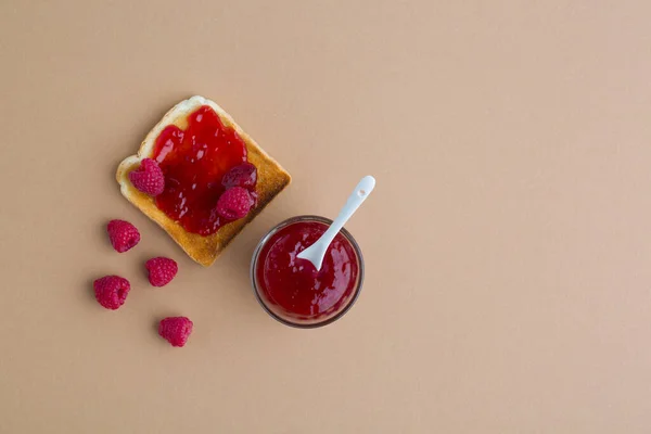 Toast Mit Marmelade Und Himbeere Auf Beigem Tisch — Stockfoto
