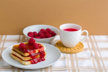 Bir fincan kırmızı çay ve kızarmış ekmek.