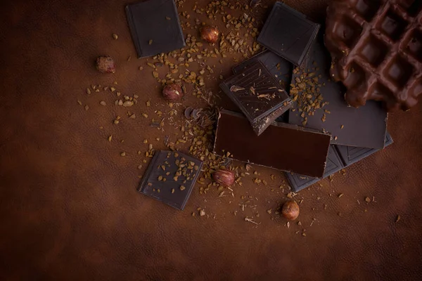 stock image Composition of bars and pieces of different milk and dark chocolate, grated cocoa brown background top view close up