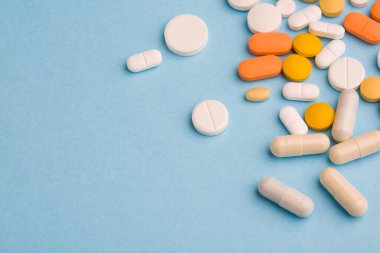 Çeşitli ilaç tıp hap, tablet ve kapsüller mavi zemin üzerine. Metin için yer kopyalayın