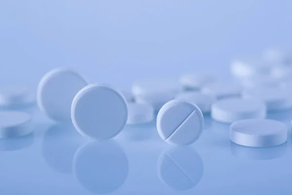 明るい青の背景に白い薬のマクロショット — ストック写真