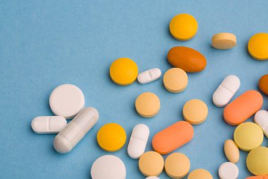 Çeşitli ilaç tıp hap, tablet ve kapsüller mavi zemin üzerine. Metin için yer kopyalayın