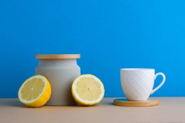 A front view of lemon decorated with tea in blue background