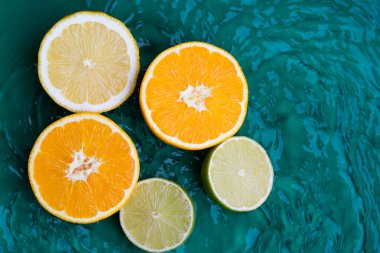 Yeşil su arka planında turunçgiller, eşmerkezli daireler ve dalgalanmalar. Yaz konsepti tazeleniyor, kopyalama alanı