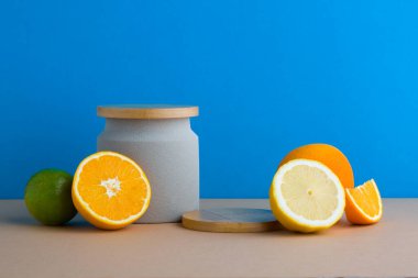 Mavi arkaplan kompozisyonunda ahşap podyumla dekore edilmiş turunçgil manzarası