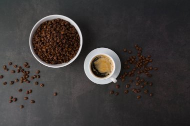 Arka planda kavrulmuş fasulyeli kahve fincanı. Metnin için kopyalama alanı olan üst görünüm