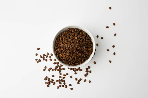 Coffee beans in the orange bowl. Top view. Isolated on white background.copy space