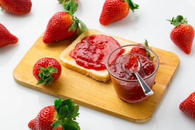 Beyaz bir arka planda çilek reçelli ekmek ve çilek meyvesinin kuş bakışı görüntüsü