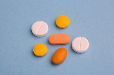 Mavi arka planda vitamin hapları. Beslenme takviyeleri ve diyet için haplar. Tıbbi konsept. Tamamlayıcı ve tıbbi ürünler. Pankart