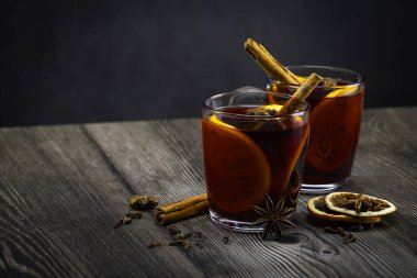 Bir bardak sıcak şarap ve portakal dilimi. Ahşap bir masada sıcak şarap ve malzemeler. El bilgisayarı atışı