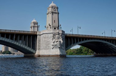 Boston 'daki Longfellow köprüsü. Köprüde, heykeller ve tepesinde kubbe olan kule benzeri bir yapı da dahil olmak üzere birden fazla kemer ve dekoratif unsurlar yer alıyor. Yukarıdaki açık gökyüzü mimari tasarımı tamamlıyor..