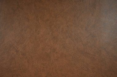 Kalıplı kahverengi deri bir yüzeye yakın çekim. Doku detaylıdır, ince çizgiler ve renk varyasyonlarıyla, kahverenginin koyu tonlarından açık tonlarına kadar değişir..