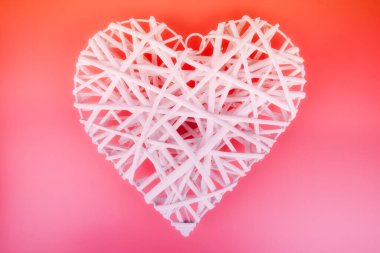 Beautiful white wicker heart set against a vibrant pink gradient background, symbolizing love and romance. Perfect for Valentine's Day, wedding themes, and decorative or artistic projects. clipart