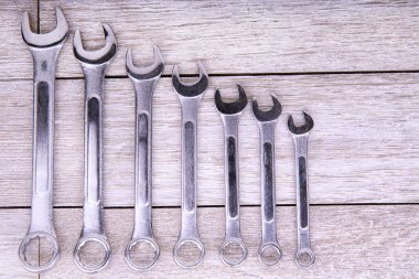 Kırsal ahşap arka planda boyut sırasına göre dizilmiş metal anahtarlar. Sanayi ortamlarında mekanik, inşaat, DIY projeleri ve profesyonel araç gereçleri ile ilgili konular için ideal.