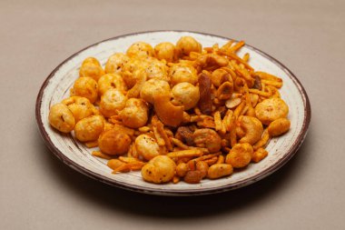 Hint baharatlı chatpata karışımı Makhana ve kuru meyveli, beyaz bir tabakta. Ön görünüm.