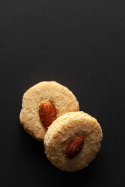 Siyah arka planda iki bademli kurabiye. Tepeden tırnağa. Besin düzlüğü.