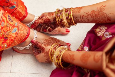 Hint Düğün Töreni Konsepti. Hintli bir gelin başka bir kadın tarafından gümüş halhallar takılır..