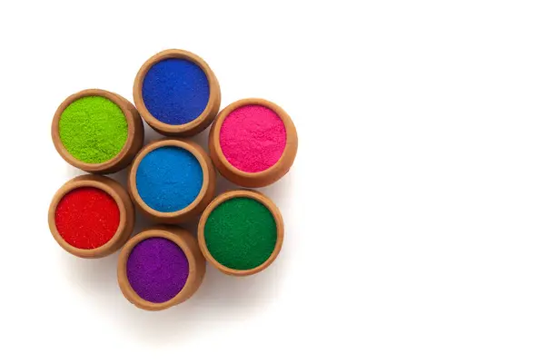 stock image Top view of colorful traditional Rangoli powder in clay pots isolated on a white background.