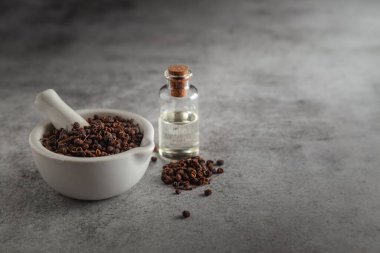 Kuru organik Tomar Toeds (Zanthoxylum armatum), beyaz seramik havan ve tokmak, temel yağ ile birlikte.