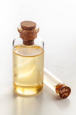 Yuvarlak cam bir şişe ve doğal ilaçlar ve kozmetik ürünleri için gerekli olan soluk sarı rengi içeren bir şişe..